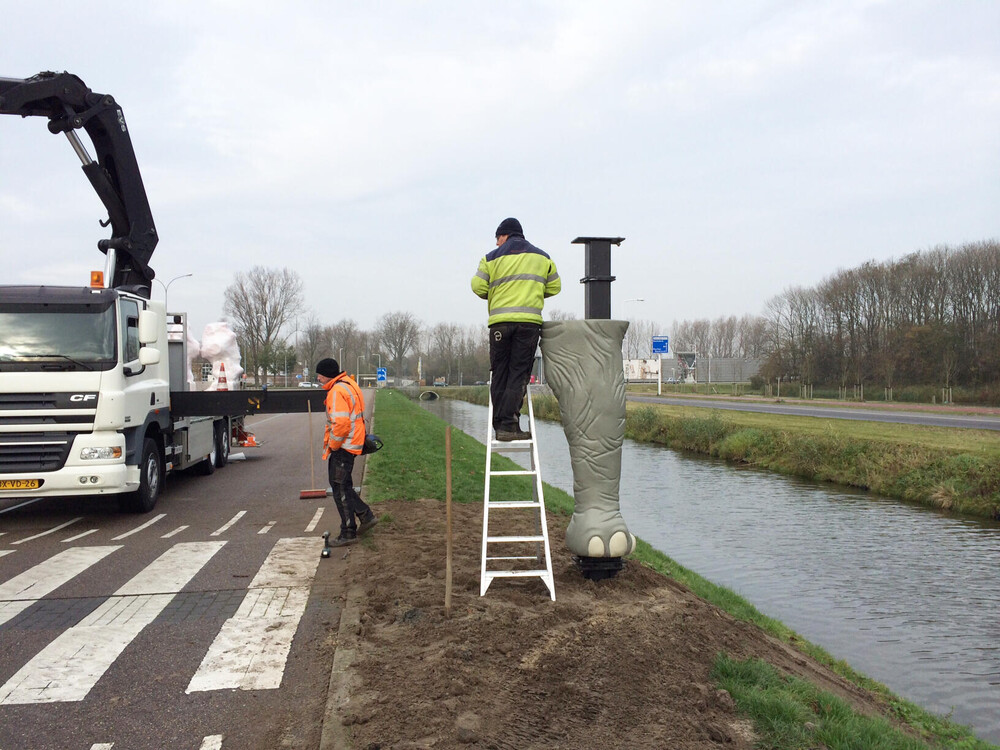 Grote dierenpoten als 3D effect bij reclamezuilen