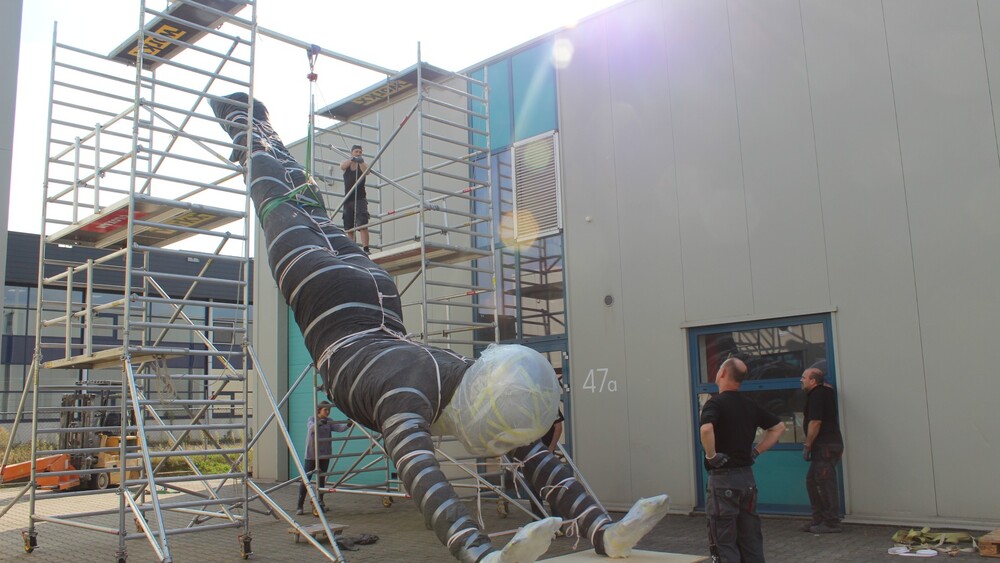 Een handstand in NEMO, een polyester kunstwerk voor NEMO's nieuwe tentoonstelling Humania. Het grote polyester beeld werd ontworpen door kunstenaar Florentijn Hofman en gemaakt door Blowups Reclameobjecten in Heijen.