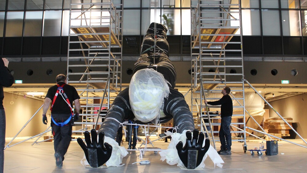 Een handstand in NEMO, een polyester kunstwerk voor NEMO's nieuwe tentoonstelling Humania. Het grote polyester beeld werd ontworpen door kunstenaar Florentijn Hofman en gemaakt door Blowups Reclameobjecten in Heijen.