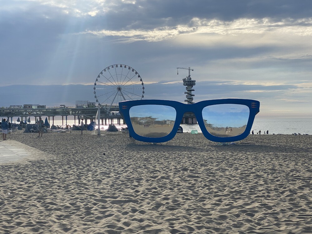 Mega grote blauwe zonnebril op het strand in Scheveningen. 